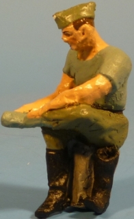 Soldat auf Km-Stein sitzend, ein Stiefel ausgezogen 