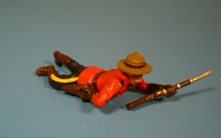 Mounty liegend mit Gewehr, Revolver aus Tasche ziehend