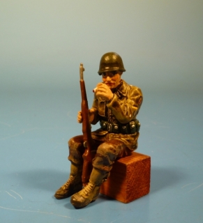 US GI sitzend mit Gewehr eine Zigarette rauchend